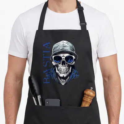 Tablier de cuisine noir avec illustration crâne casquette et texte BASTIA bleu vertical.