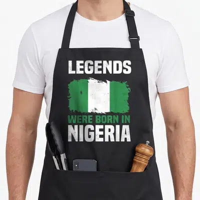 Tablier de cuisine noir avec le drapeau nigérian et le texte Legends Were Born In Nigeria en blanc et vert.