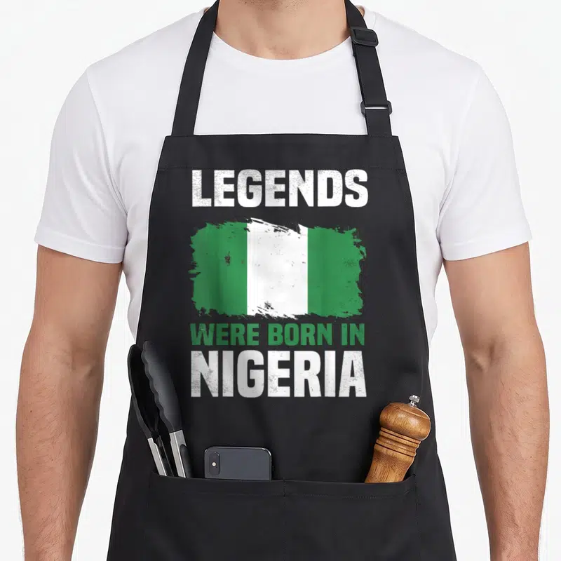 Tablier de cuisine noir avec le drapeau nigérian et le texte Legends Were Born In Nigeria en blanc et vert.