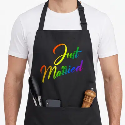 Tablier de cuisine noir avec inscription Just Married en couleurs arc-en-ciel vives.