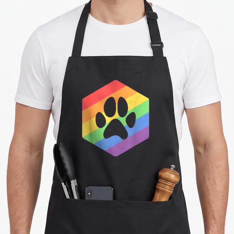 Tablier de cuisine noir avec un hexagone arc-en-ciel et une patte d'animal grise imprimée au centre.