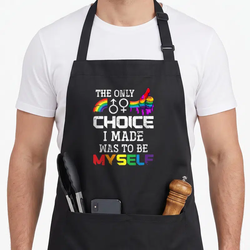 Tablier de cuisine noir avec main rainbow, symboles de genre et texte The Only Choice I Made Was To Be Myself en blanc et arc-en-ciel.