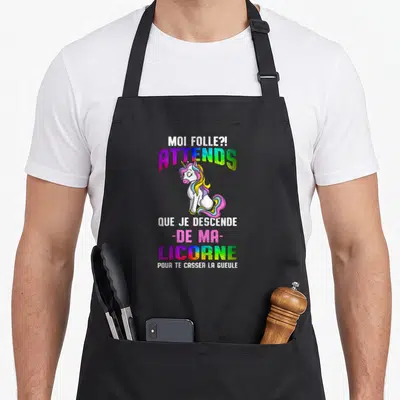 Tablier de cuisine noir avec une licorne multicolore et le texte humoristique Moi folle attends que je descende de ma licorne pour te casser la gueule.