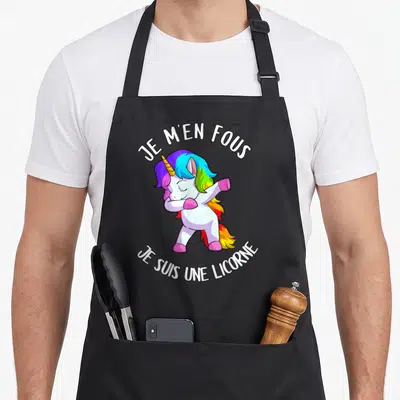 Tablier de cuisine noir avec une licorne aux cheveux arc-en-ciel effectuant un dab et le texte Je m'en fous je suis une licorne.