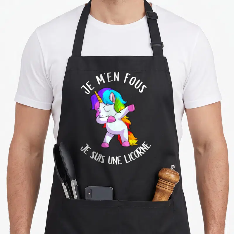 Tablier de cuisine noir avec une licorne aux cheveux arc-en-ciel effectuant un dab et le texte Je m'en fous je suis une licorne.