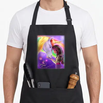 Tablier de cuisine noir avec une illustration colorée d'une fille touchant le museau d'une licorne aux cheveux multicolores sur fond violet.