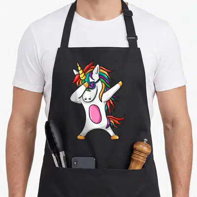 Tablier de cuisine noir avec licorne blanche effectuant un dab, perruque arc-en-ciel et lunettes violettes.