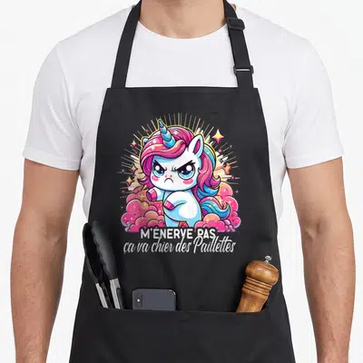 Tablier de cuisine noir avec illustration d'une licorne rose et bleue aux bras croisés et texte humoristique en blanc.