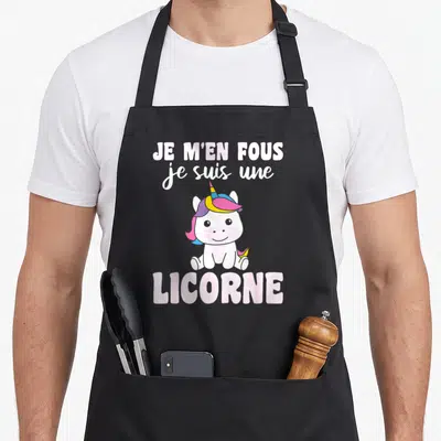Tablier de cuisine noir avec une licorne rose et un texte humoristique en lettres roses et blanches.