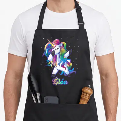 Tablier de cuisine noir avec licorne blanche en train de faire le dab et nom Élée en lettres colorées.