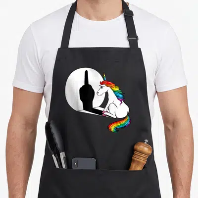 Tablier de cuisine noir avec une licorne rainbow observant une ombre levant le.