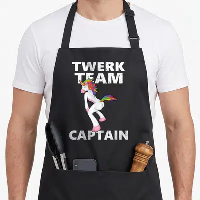 Tablier de cuisine noir avec une licorne blanche en train de twerker et des textes blancs Twerk Team Captain.