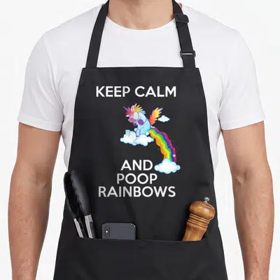 Tablier de cuisine noir avec une licorne ailée bleue et un arc-en-ciel coloré sur fond blanc.