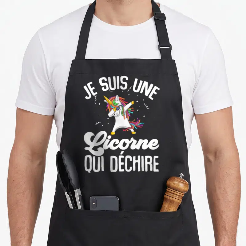 Tablier de cuisine noir avec une licorne blanche faisant un dab et portant des lunettes de soleil colorées.