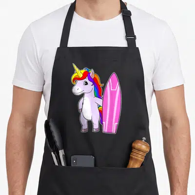 Tablier de cuisine noir avec illustration d'une licorne surfeuse rose et une planche de surf arc-en-ciel