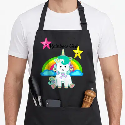 Tablier de cuisine noir avec une licorne blanche, un arc-en-ciel et des étoiles roses et jaunes.