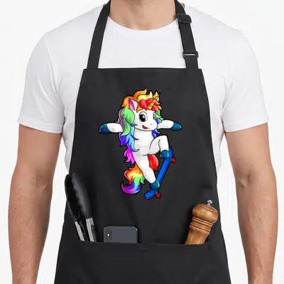 Tablier de cuisine noir avec illustration d'une licorne blanche sur planche à roulettes aux couleurs vives.