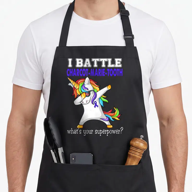 Tablier de cuisine noir avec une licorne en train de faire le dab et un ruban bleu.