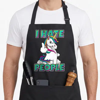 Tablier de cuisine noir avec une licorne blanche faisant un geste d'insulte sous les mots « I HATE PEOPLE » en lettres colorées.