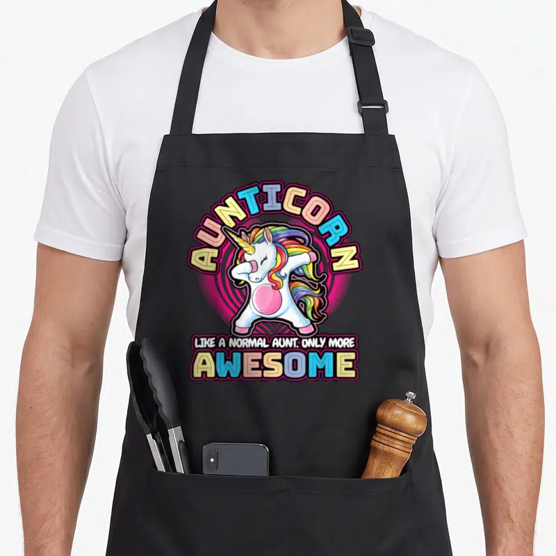 Tablier de cuisine noir avec une licorne blanche en train de faire le dab et le mot Aunticornz en arc de cercle.