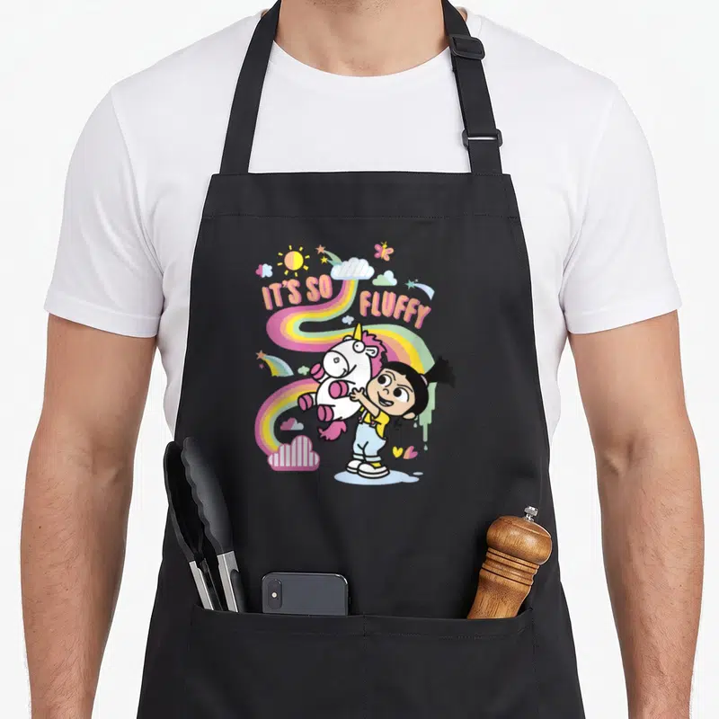 Tablier de cuisine noir avec Agnes tenant un poney licorne rose et blanc sous un arc-en-ciel.