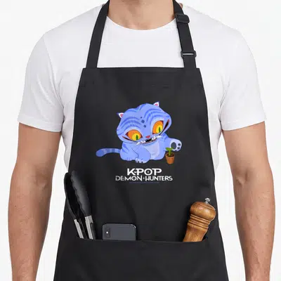 Tablier de cuisine noir avec un tigre bleu cartoon aux yeux orange tenant une petite plante verte en pot.