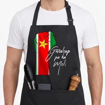 Tablier de cuisine noir avec un poing ganté des couleurs du drapeau Guadeloupe et l'inscription Gwaloup pa ka Moli en lettres blanches.