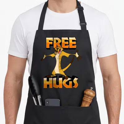 Tablier de cuisine noir avec Timon les bras ouverts et l'inscription FREE HUGS en lettres orange et blanches.