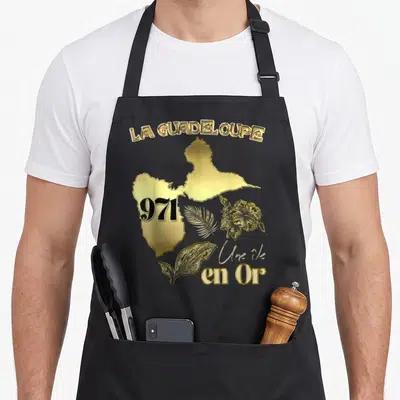 Tablier de cuisine noir avec carte dorée de Guadeloupe 971 hibiscus et feuilles tropicales.