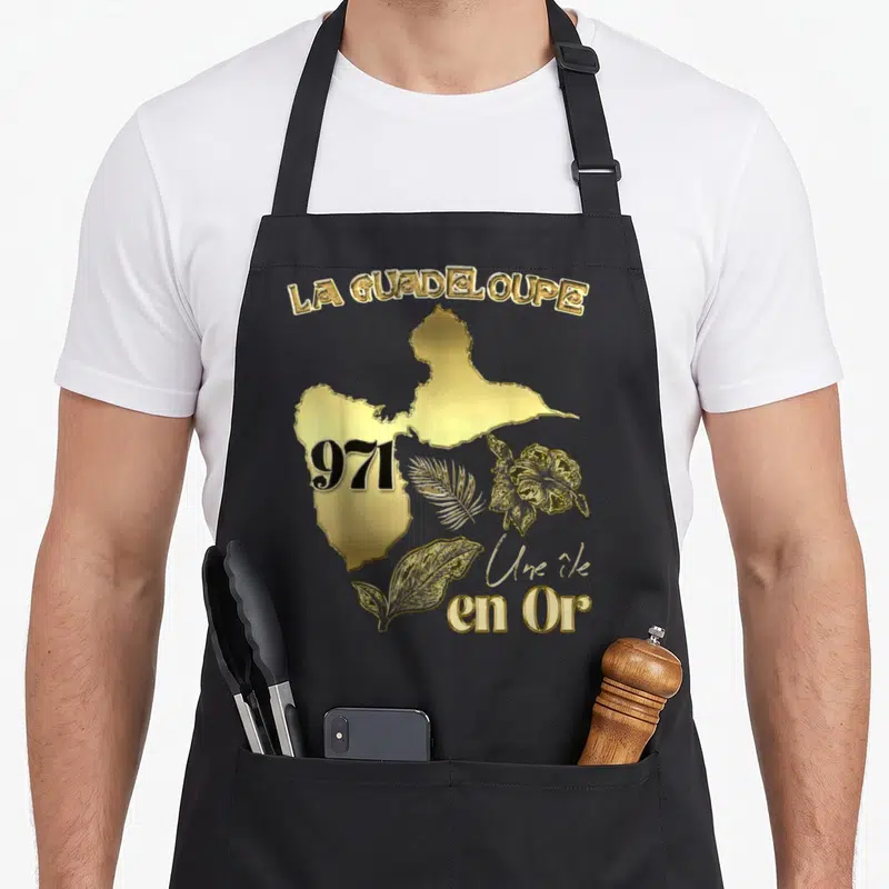 Tablier de cuisine noir avec carte dorée de Guadeloupe 971 hibiscus et feuilles tropicales.