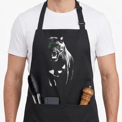 Tablier de cuisine noir avec illustration d'une panthère aux yeux verts et dents apparentes.