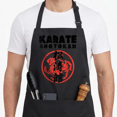 Tablier de cuisine noir avec logo Karate Shotokan, cercle rouge et caractères calligraphiques noirs au centre.