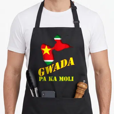 Tablier de cuisine noir avec carte Guadeloupe drapeau et texte Gwada Pa Ka Moli en lettres jaunes et vertes.