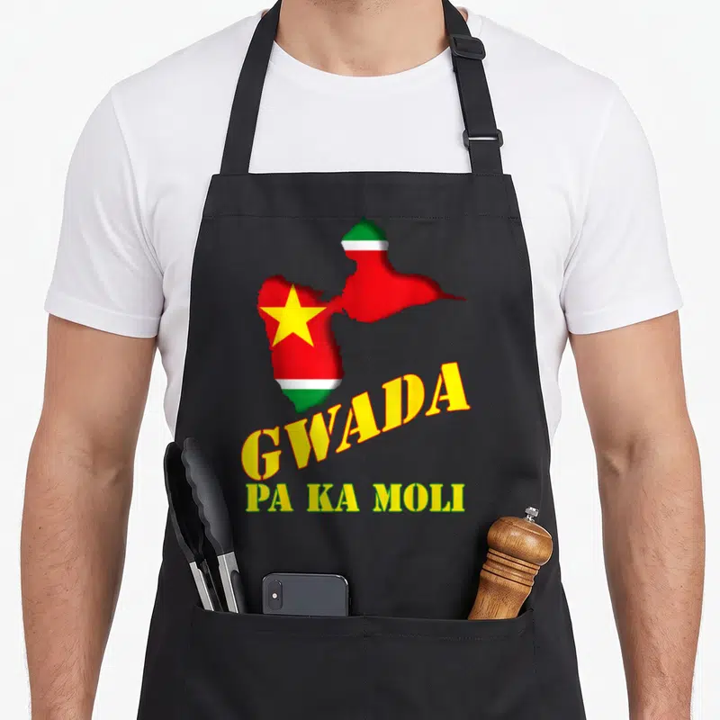 Tablier de cuisine noir avec carte Guadeloupe drapeau et texte Gwada Pa Ka Moli en lettres jaunes et vertes.
