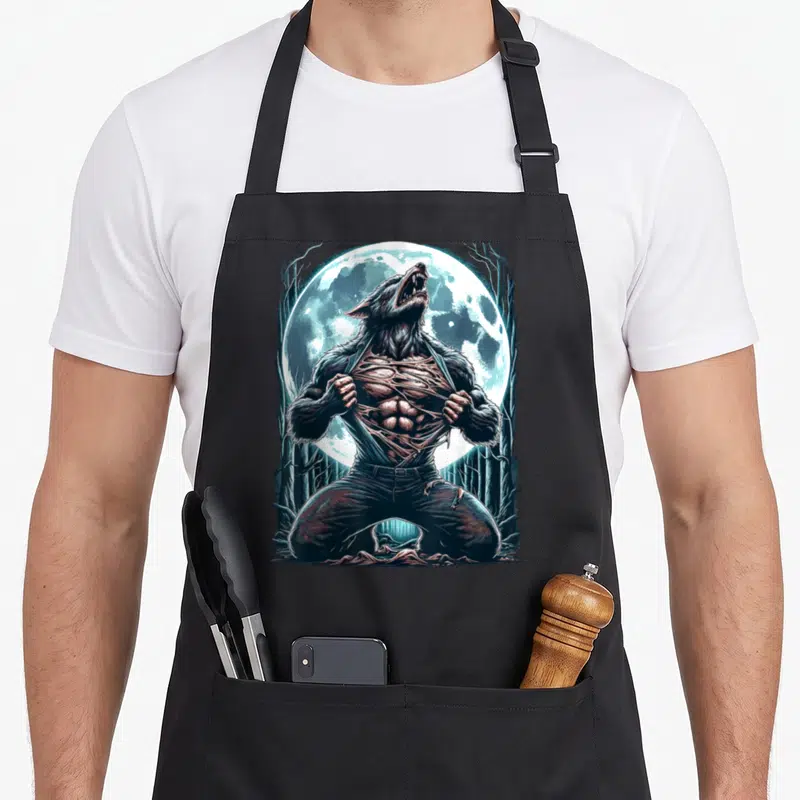 Tablier de cuisine noir avec illustration d'un loup-garou déchirant sa chemise sous une pleine lune dans une forêt.