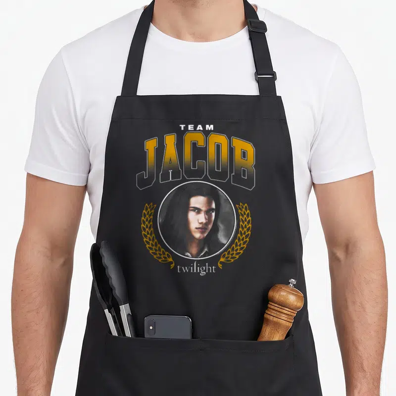 Tablier de cuisine noir avec illustration de Jacob Black et texte Team Jacob en lettres dorées et blanches.