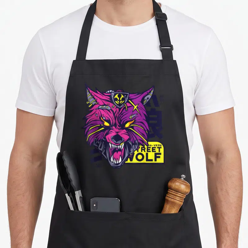 Tablier de cuisine noir avec illustration d'un loup cybernétique magenta et des inscriptions graphiques jaunes et bleues.