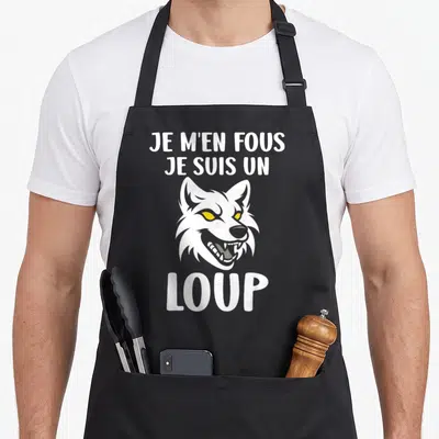 Tablier de cuisine noir avec une tête de loup blanche aux yeux jaunes et le texte Je m'en fous je suis un loup.