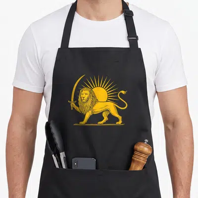 Tablier de cuisine noir avec un lion doré tenant un sabre devant un soleil rayonnant.