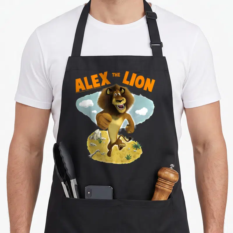 Tablier de cuisine noir avec illustration d'un lion brun courant sur fond de désert et nuages.