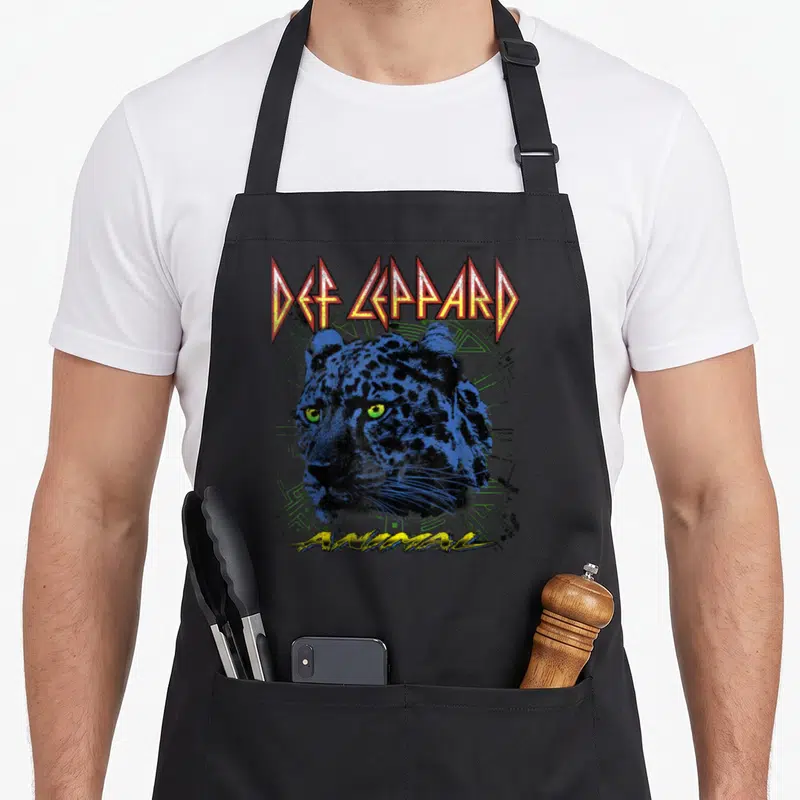 Tablier de cuisine noir avec tête de léopard bleue, yeux verts et texte Def Leppard Animal en lettres stylisées.