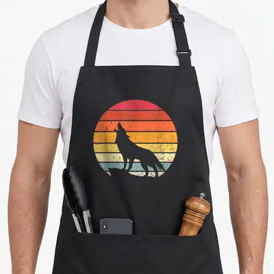 Tablier de cuisine noir avec silhouette loup hurlant devant un soleil couchant rayé retro