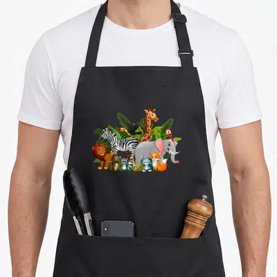 Tablier de cuisine noir avec un groupe d'animaux de zoo colorés incluant lion, zèbre, éléphant et girafe parmi des feuilles vertes.