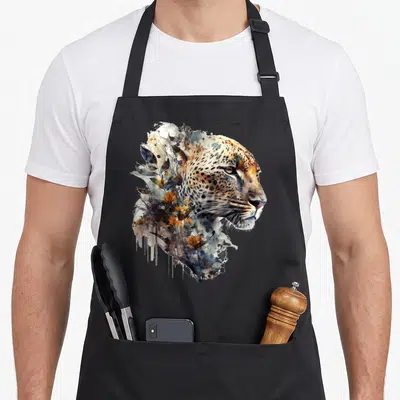 Tablier de cuisine noir avec une illustration artistique représentant un léopard aux couleurs douces et des motifs floraux intégrés.