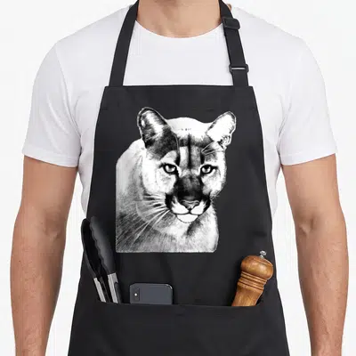 Tablier de cuisine noir avec illustration détaillée d'un puma ou wildcat au trait fin noir et blanc.