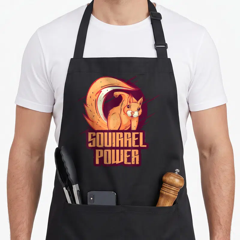 Tablier de cuisine noir avec illustration d'un écureuil orange et du texte Squirrel Power en lettres capitales stylisées.