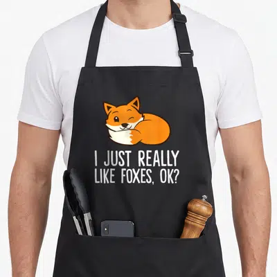 Tablier de cuisine noir avec un renard orange souriant et le texte I JUST REALLY LIKE FOXES, OK?
