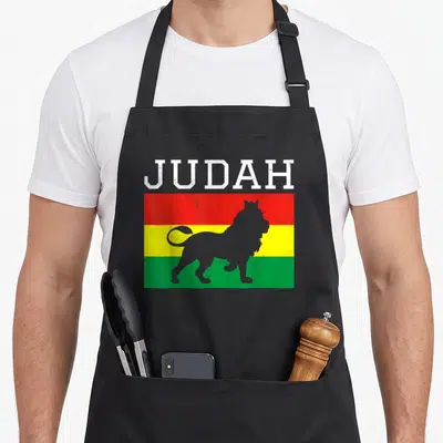 Tablier de cuisine noir avec un drapeau tricolore rouge jaune vert et la silhouette d'un lion sous le mot JUDAH en lettres blanches.