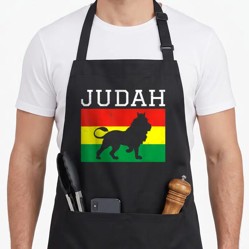 Tablier de cuisine noir avec un drapeau tricolore rouge jaune vert et la silhouette d'un lion sous le mot JUDAH en lettres blanches.