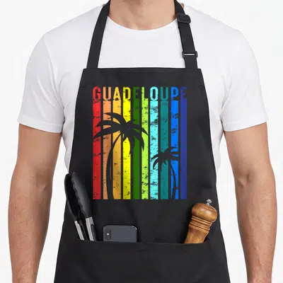 Tablier de cuisine noir avec inscription Guadeloupe et palmiers sur fond de bandes verticales colorées style vintage